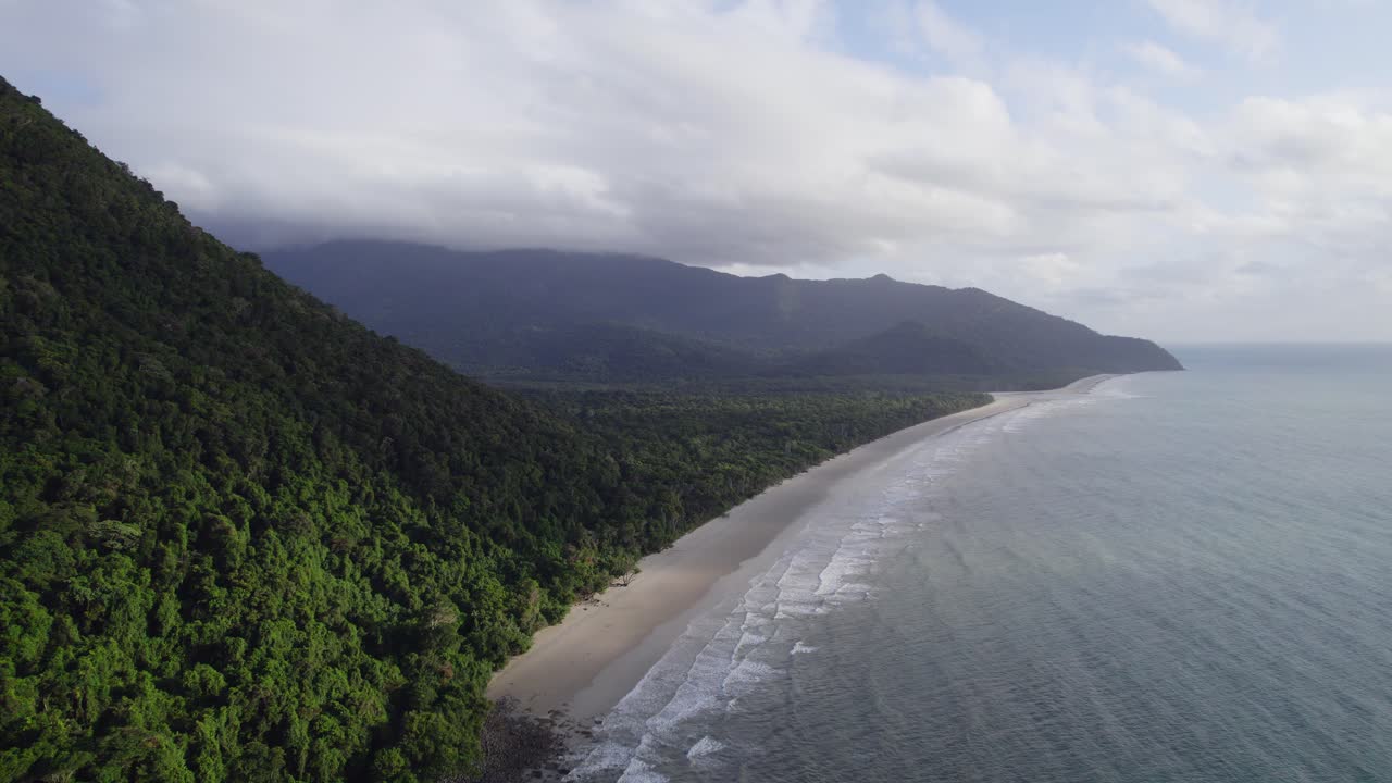 olas oceánicas salpicando en la orilla arenosa en el parque nacional daintree, lejano norte de queensland, australia - toma aérea de drones