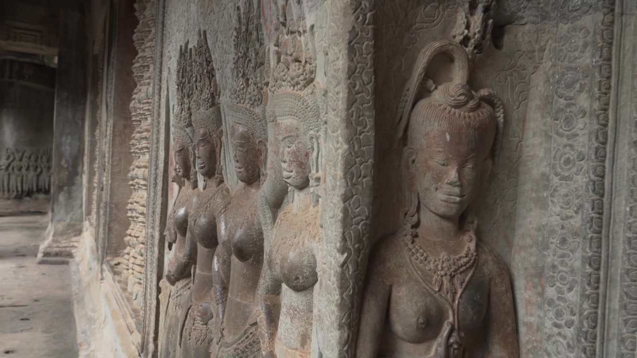 Fila di antiche sculture in pietra Devata ad Angkor Wat, Cambogia.