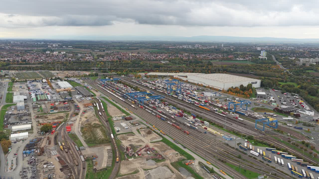 Omfattende luftfoto av en stor jernbaneterminal og intermodal containerterminal. Godstog og lastebiler flytter last i et enormt logistikksenter.