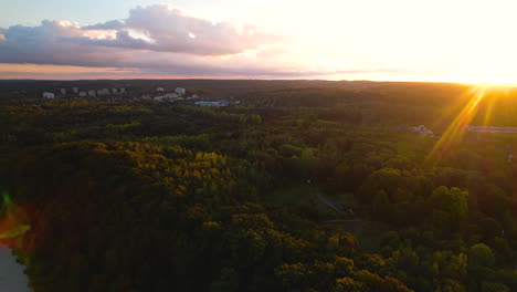 Luftaufnahme-Von-Goldenen-Orangefarbenen-Sonnenuntergangsfackeln-über-Der-Abendlichen-Waldlandschaft-Am-Horizont