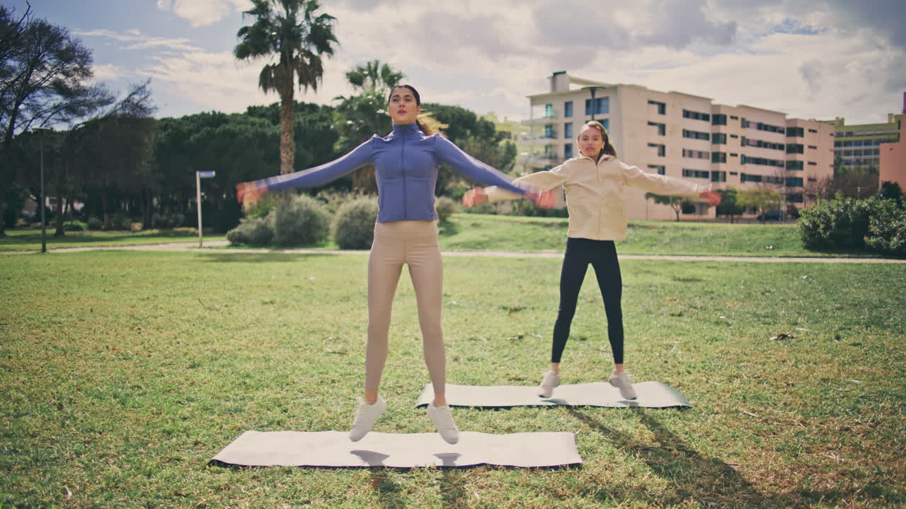 mujeres activas saltando jack haciendo ejercicio parque de verano. atleta niñas cuerpo de entrenamiento
