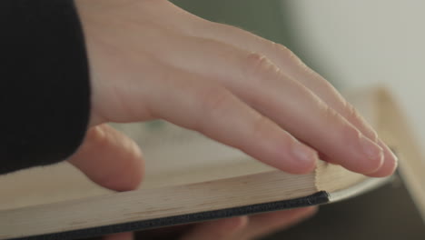 Primer-Plano-De-La-Mano-Femenina-Pasando-Páginas,-Leyendo-Y-Cerrando-El-Libro-Antiguo-En-La-Biblioteca