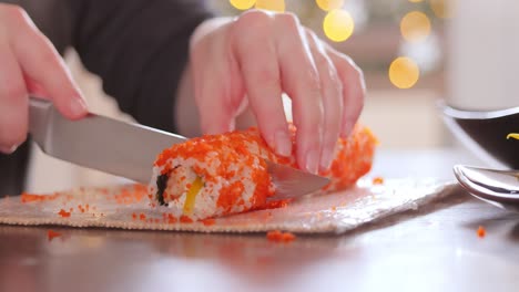 making sushi at home kitchen. woman hands rolling homemade sushi.