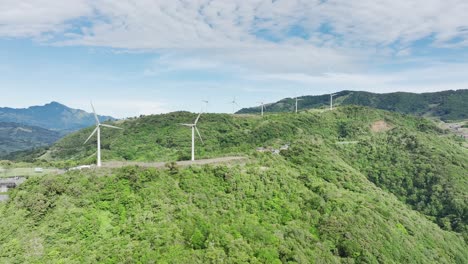 wind turbines adorning the rolling hills, aerial drone movement from right to left