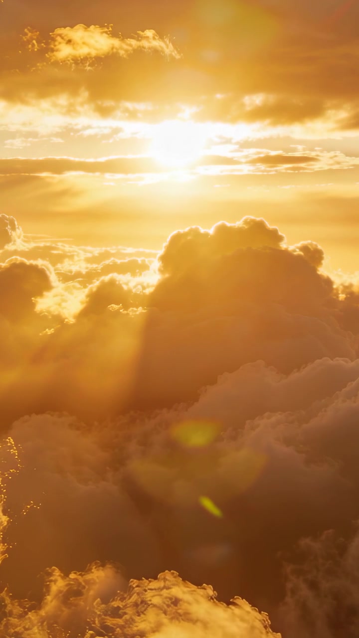 Vertical video: Shifting sun sending crepuscular rays over cumulus clouds at sunset, lens flare