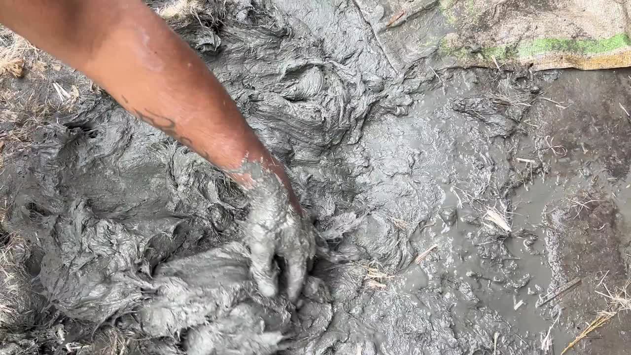 un niño mezclando barro para hacer ídolos durante el durga puja en bengal, india