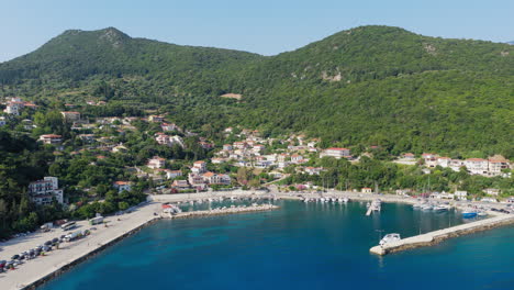 poros port surrounded by lush green hills on kefalonia island, ionian sea, drone shot, panoramic