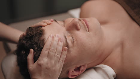 chiropractor is curing headache of male patient massaging head by hands manual therapy for health and relax