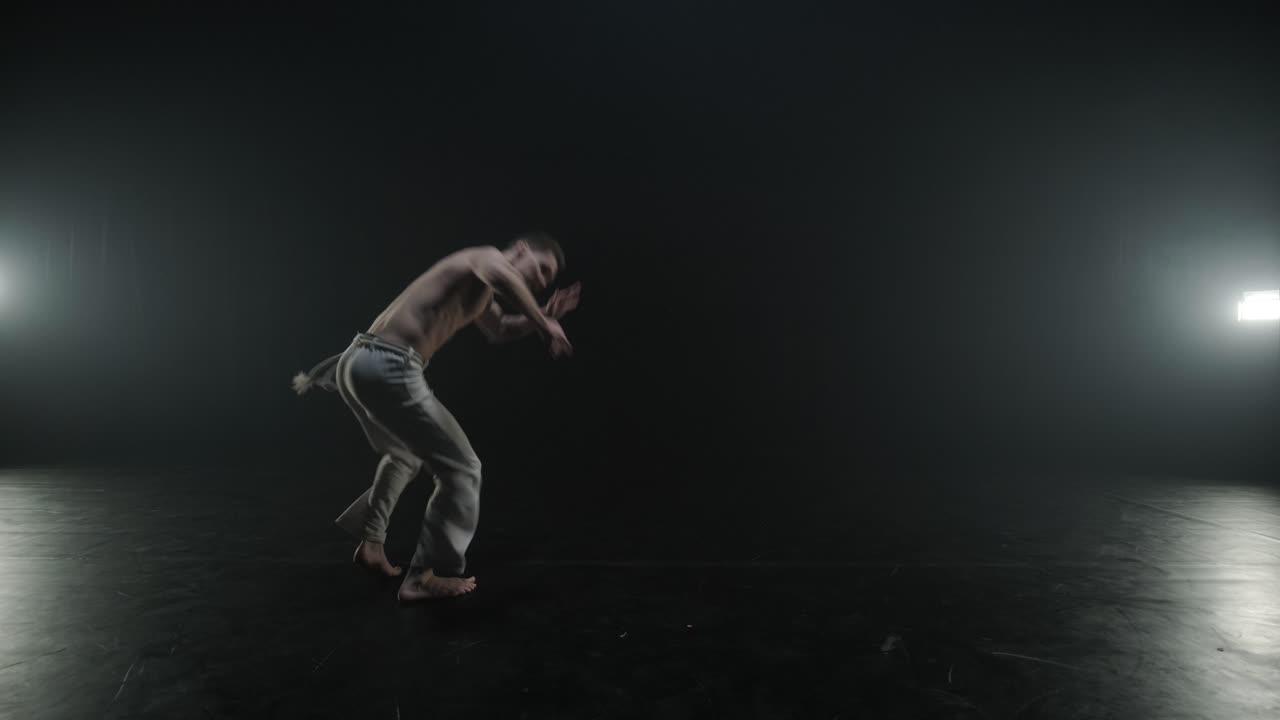luchadores de capoeira realizando movimientos dinámicos en el escenario. artes marciales, danza y acrobacias en acción. atletas de pecho desnudo mostrando fuerza, flexibilidad y técnica bajo los reflectores