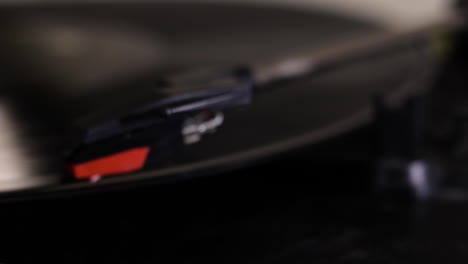 a close up shot of a record player needle being moved out of focus onto a spinning record-vinyl