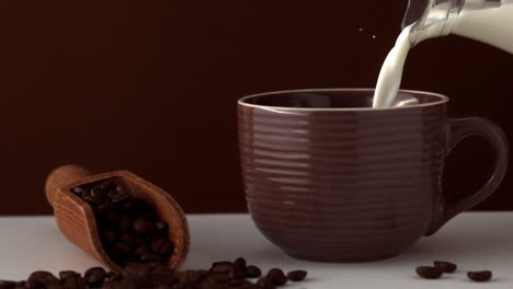 la leche se vierte en la taza de café marrón