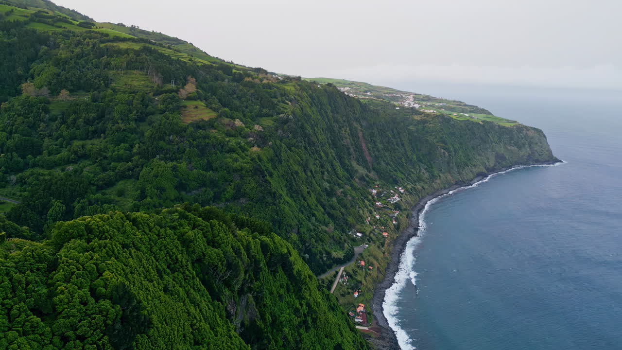 isla volcánica lavando el océano en un día nublado. vista de avión no tripulado ondas de mar oscuras espumando