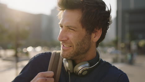 close up portrait of cool attractive caucasian man looking confident smiling at camera in city at sunset enjoying urban commuting lifestyle