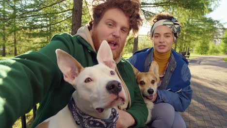 couple and their dogs enjoying a sunny day in the park