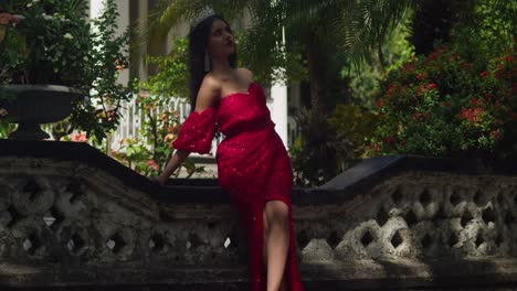 en las profundidades sombrías de un castillo caribeño, el vestido rojo de una joven proyecta un sorprendente contraste contra la vieja piedra.