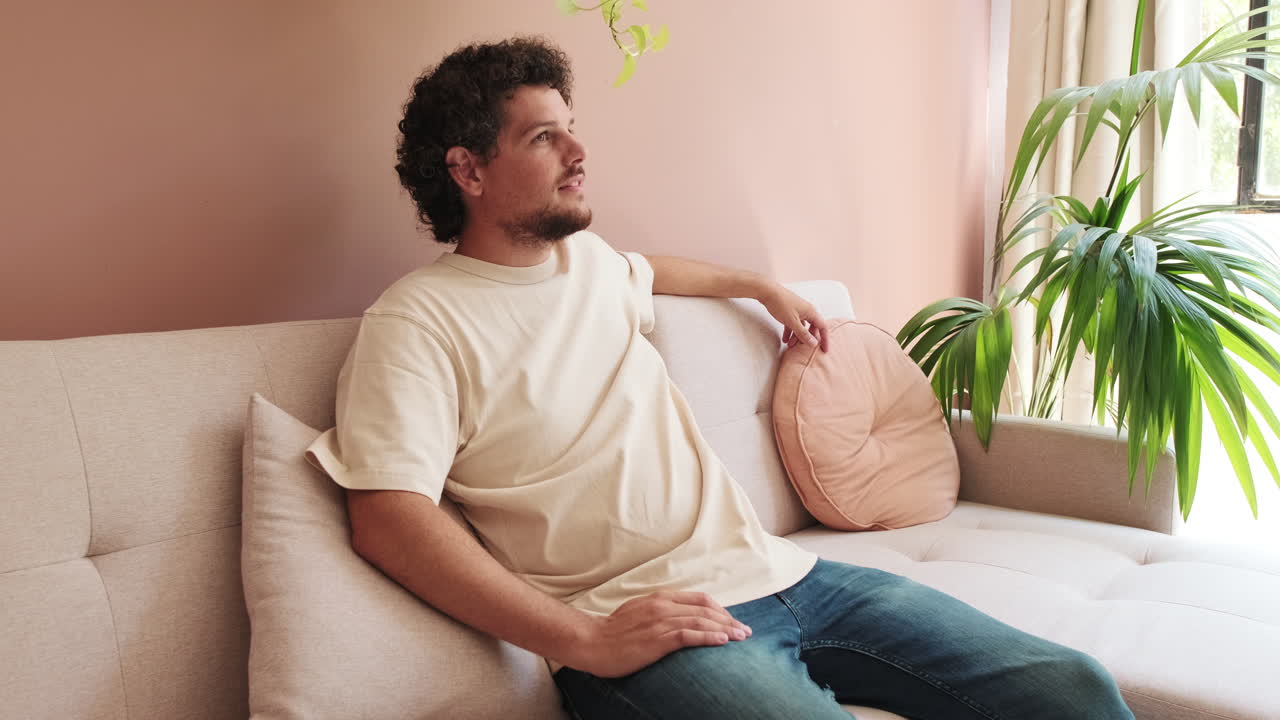 Uomo seduto sul divano che guarda fuori dalla finestra