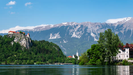 lapso de tiempo del castillo de eslovenia del lago sangrado en la cima de un acantilado con montañas en el fondo y formación de nubes