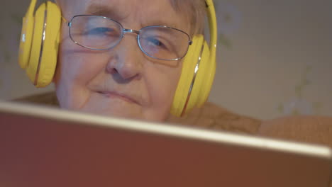 Mujer-Mayor-En-Auriculares-Usando-Tableta