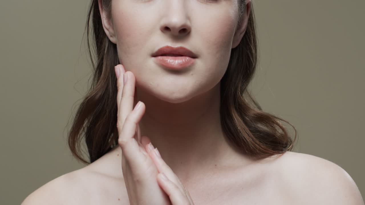 mujer caucásica con cabello marrón tocando la cara, copiar el espacio, cámara lenta
