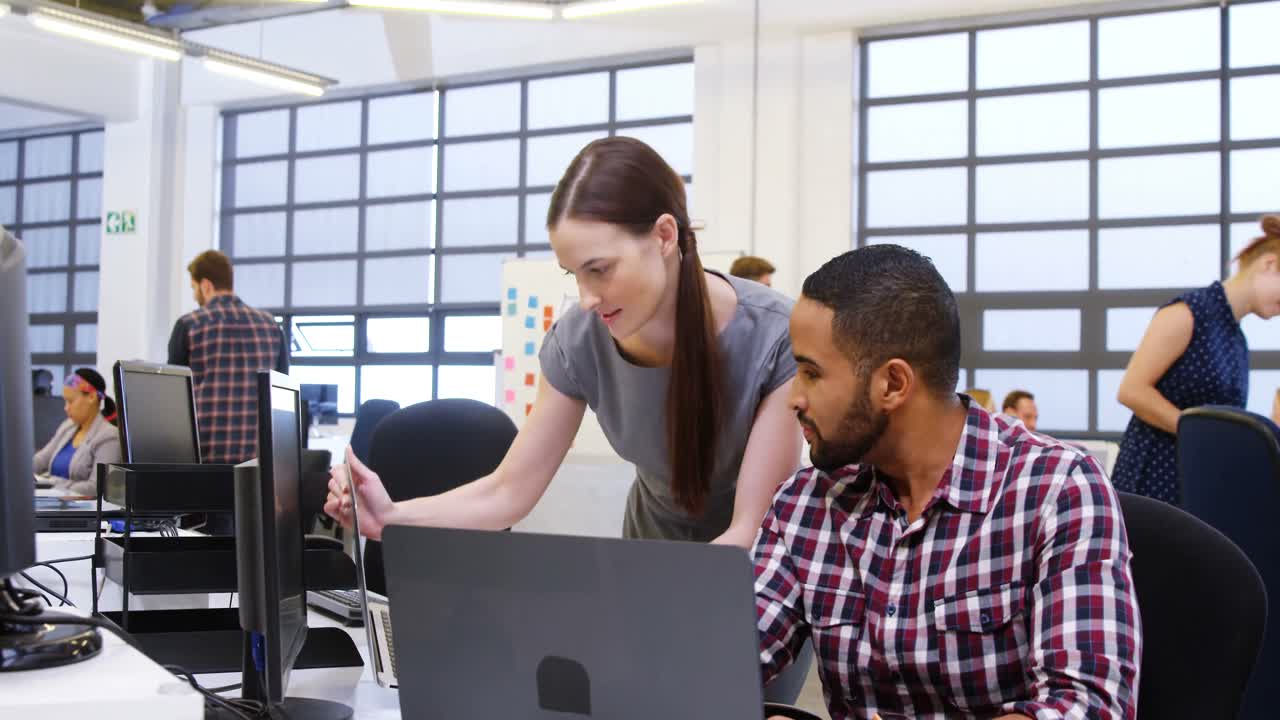 ejecutivos de negocios interactuando mientras usan portátiles