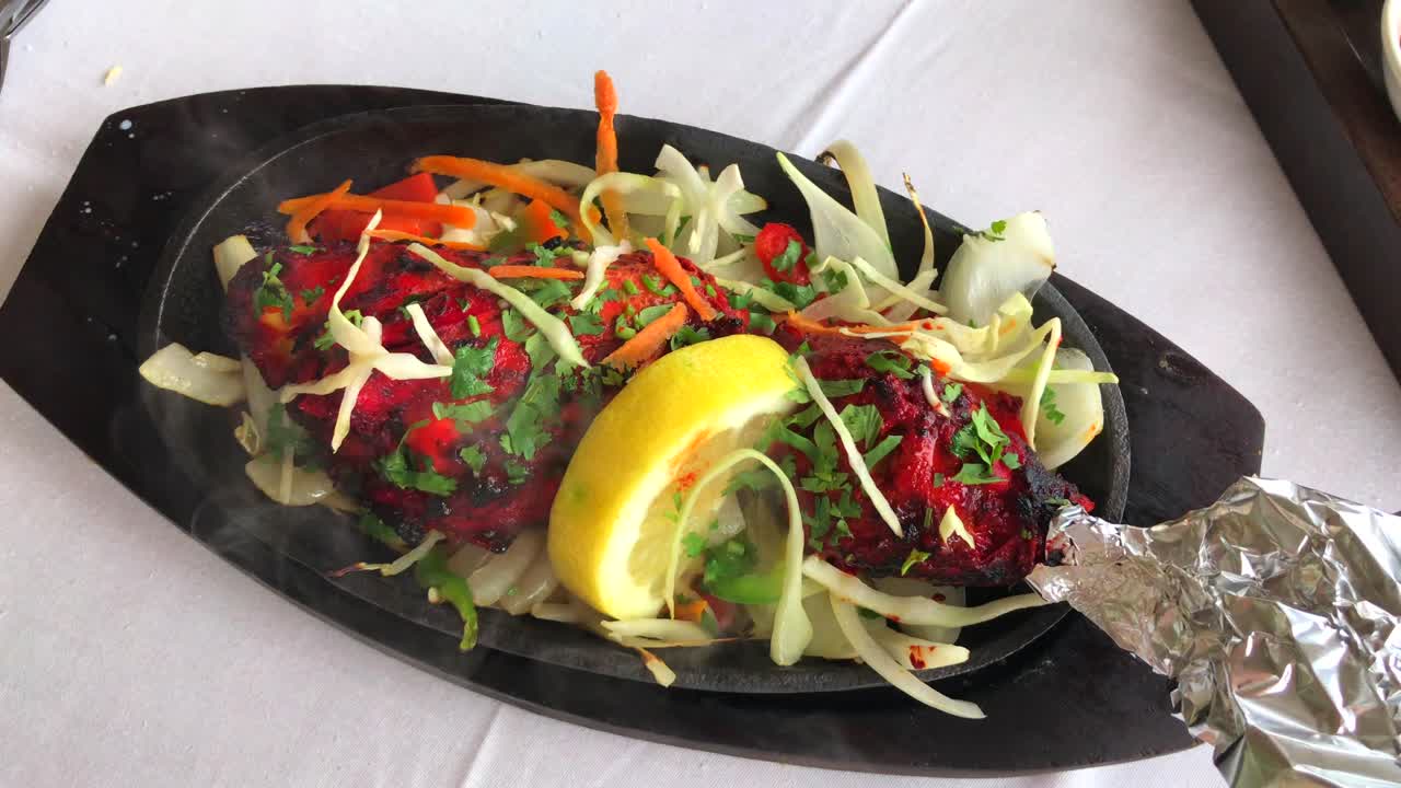 pollo tandoori tradicional indio picante con vapor en un restaurante