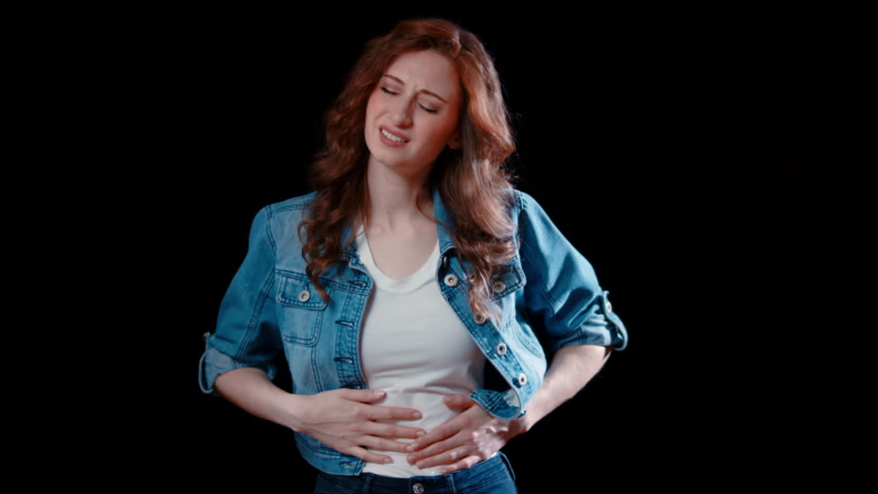 젊은 백인 여성이 복통을 가지고 있습니다.