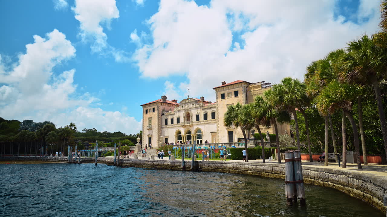 Miami, USA, 6 aprile 2026: Villa storica in stile Rinascimento italiano sul lungomare di Miami. Ampia inquadratura della facciata sul fronte mare del Vizcaya Museum and Gardens con palme e oceano sotto un cielo blu