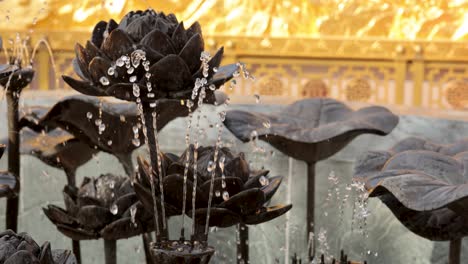 water sprays from lotus-shaped fountain sculpture