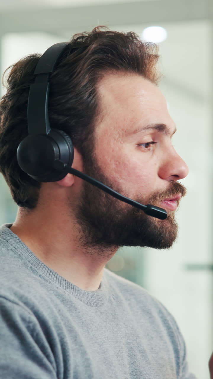 Bearded Man Wearing Headset Speaking into Microphone in Office