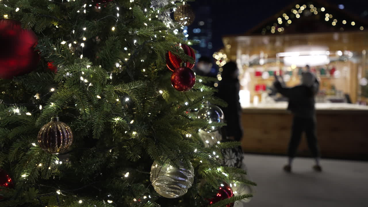 luces relucientes de un árbol de navidad con personas paseando por el mercado de la plaza gwanghwamun bazar de navidad en seúl, corea del sur