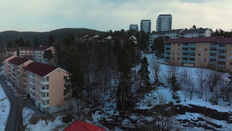 snowy sunrise sunset bjerke travbane tonsenhagen oslo norway norge aerial drone norwegian arctic winter vibrant sunset apartment buildings snow nordmarka forest icy trails upwards motion