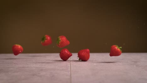 strawberries falling on surface and water splashes everywhere in super slow motion 1000fps 4k impact