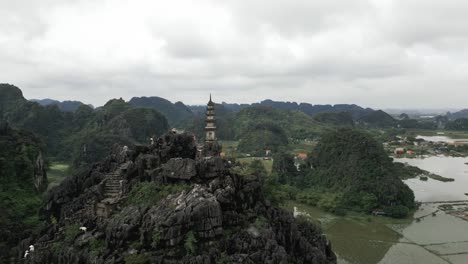 Aerial-view-of-people-crawling-stairs-to-the-wonderful-Mua-Peak-in-Nin-Bihn,-Vietnam-on-a-cloudy-day-in-lush-green-mountains