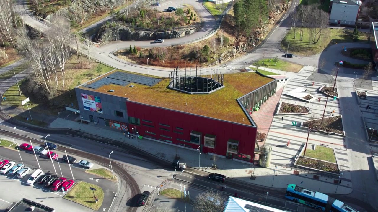 Vista aérea de Bergsjon Kulturhus elevando-se sobre o subúrbio multicultural de Gotemburgo, exibindo diversidade urbana e arquitetura moderna