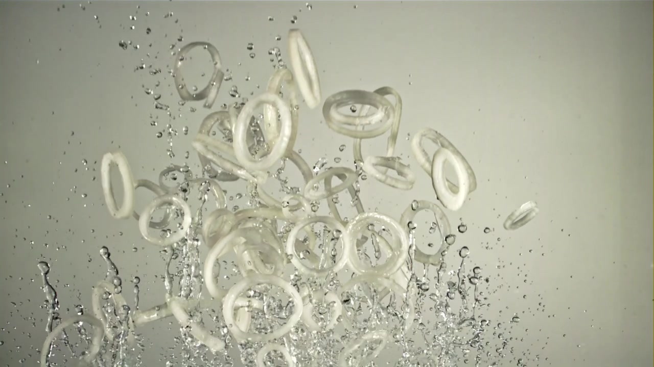水しぶきを上げて水に落ちる新鮮なオニオンリング。