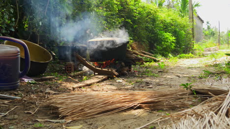 Olla-Grande-Fumando-A-Fuego-Abierto-Con-Un-Montón-De-Pajillas-En-El-Frente