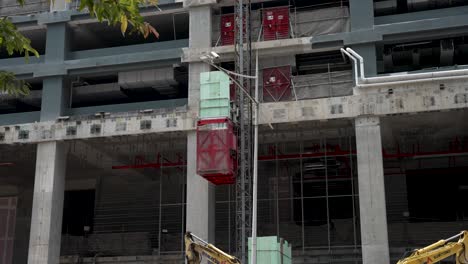 external lift moving up at construction site in downtown singapore