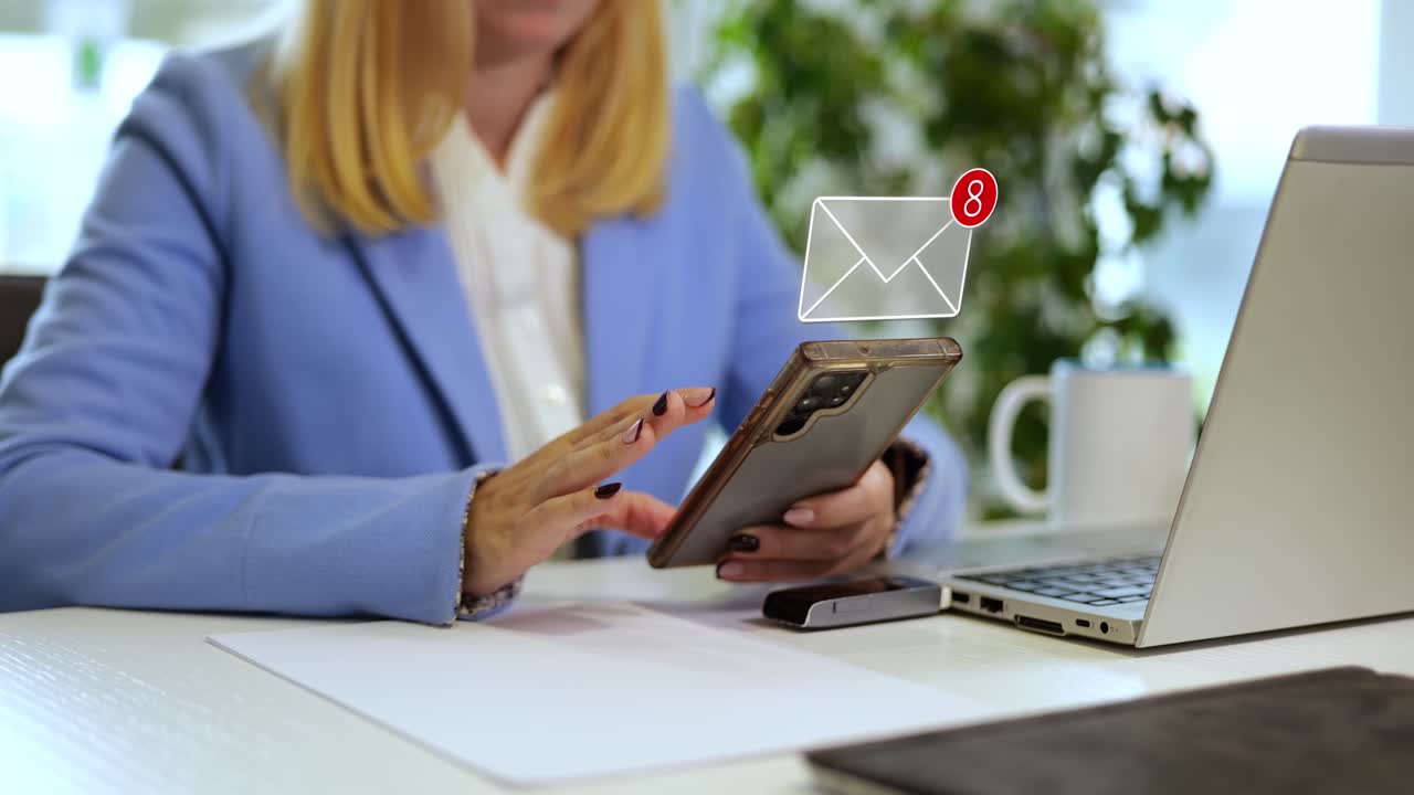Young millennial businesswoman using her phone in an office, receiving messages with animated graphics representing communication