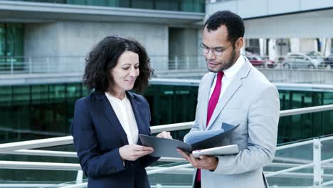 smiling business colleagues looking at papers