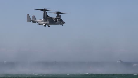 sequence of osprey aircraft flying and hovering over sea