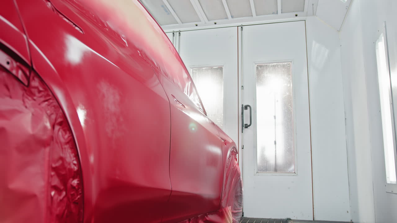 coche rojo en la cabina de pintura