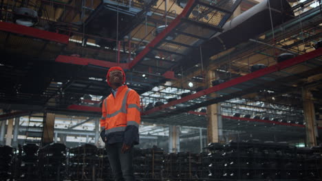 Cheerful-professional-looking-camera-at-modern-huge-manufacturing-warehouse.