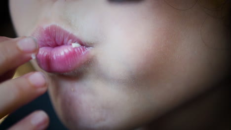 close up of a young boy's messy mouth eating popcorn in slow motion