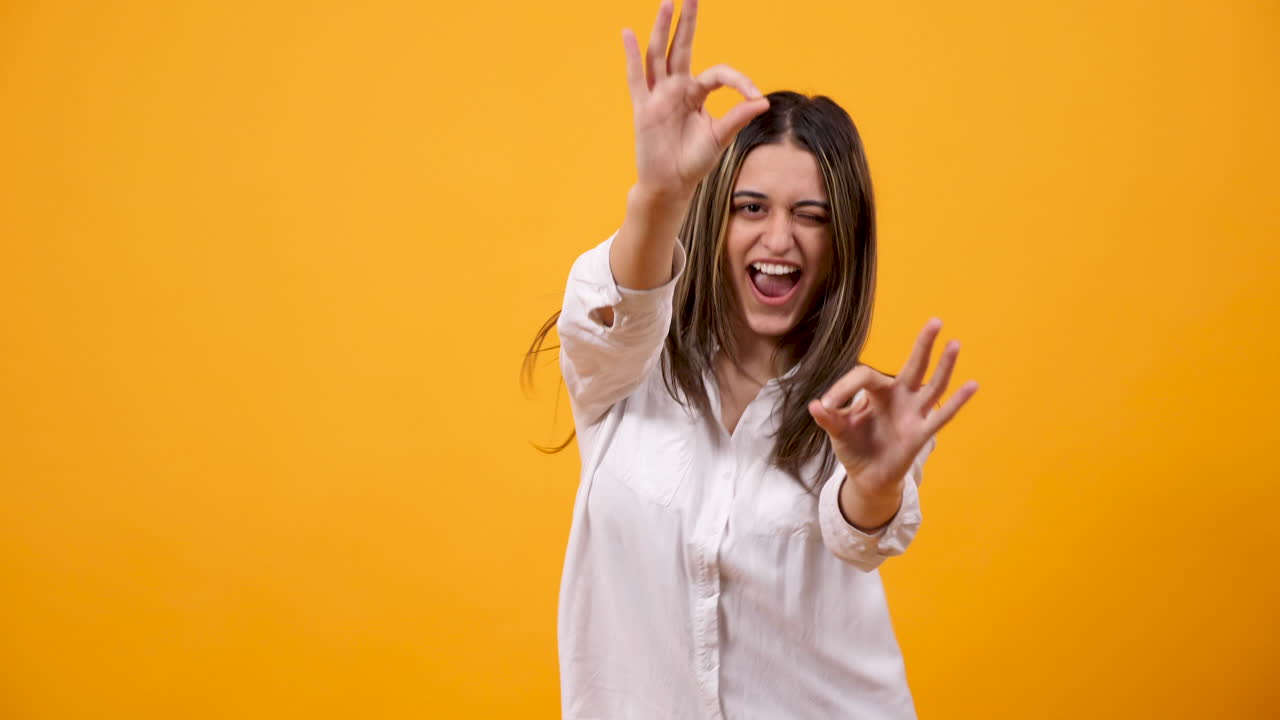 Happy Woman Giving OK Sign on Yellow Background
