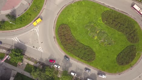 top down aerial view of roundabout street intersection with moving cars traffic.