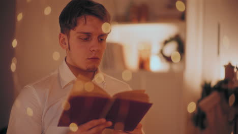 man reading book while sitting at home during christmas