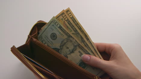 A-caucasian-woman's-hands-opening-and-showing-a-brown-wallet-containing-$40-American-Dollars