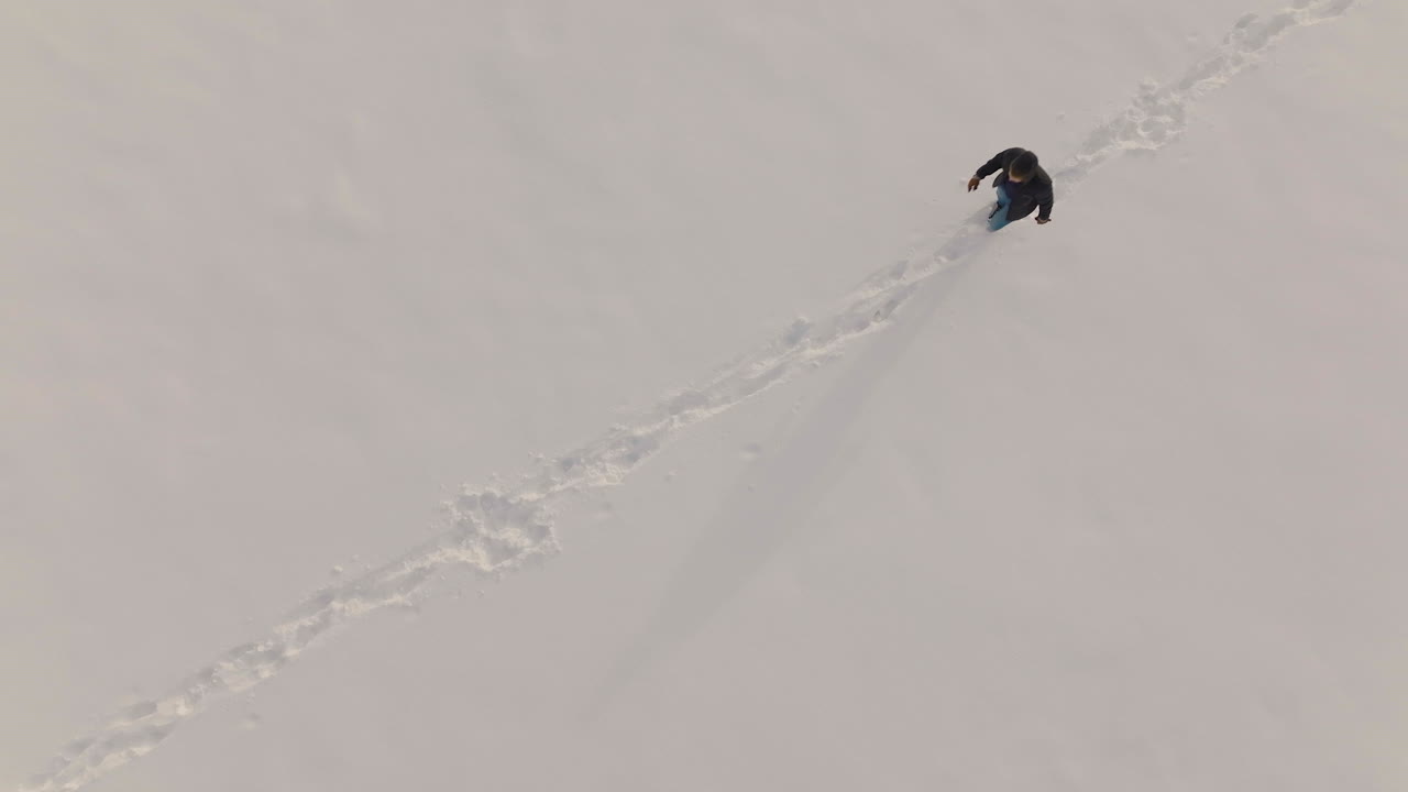 el hombre camina en diagonal a través de un campo cubierto de nieve