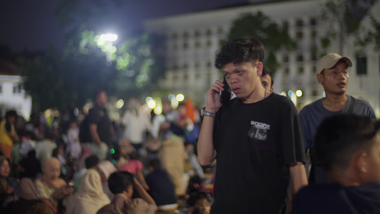 Indonesian young male tourists at Taman Fatahillah, popular tourist spot with colonial architecture, museums, and a lively atmosphere
