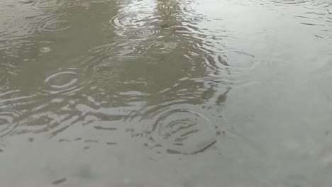 Cámara-Lenta-De-Gotas-De-Lluvia-Cayendo-En-Un-Charco-De-Barro